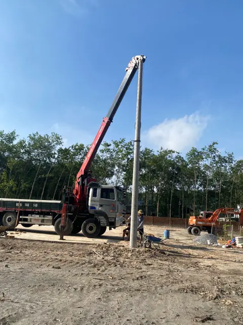 Xe cẩu dựng trụ đèn chiếu sáng sân bóng