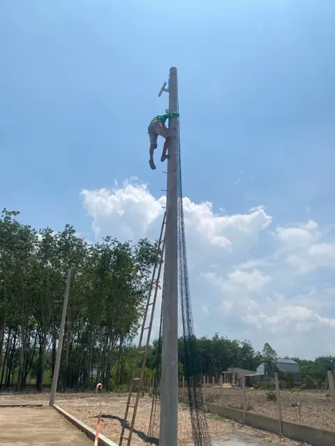 Xe cẩu dựng trụ đèn chiếu sáng sân bóng