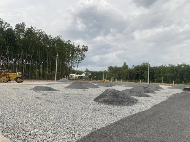Máy ủi rải và lu lèn đá nền sân