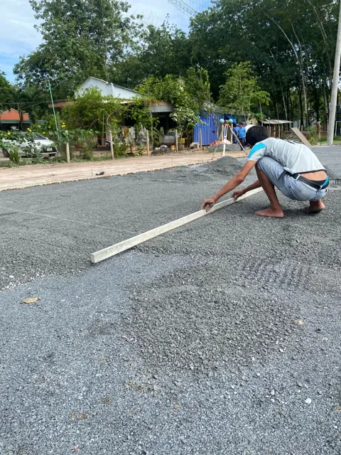 Công nhân gạt phẳng mặt nền đá